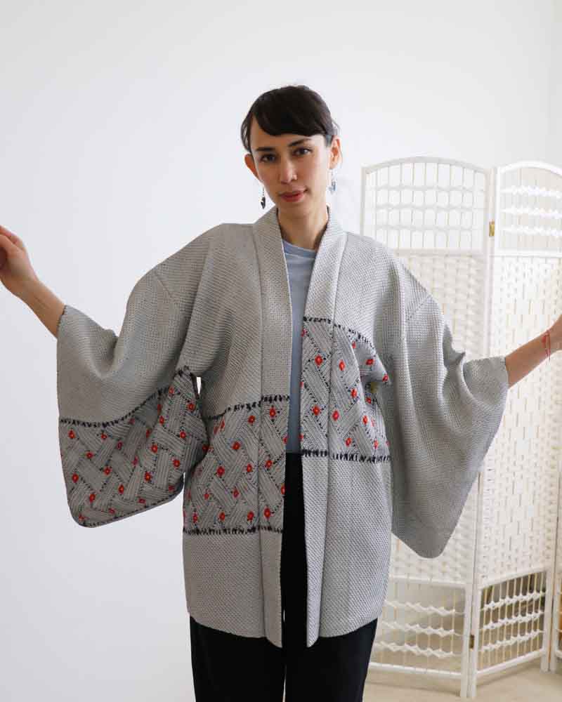 A woman wearing a blue and gray kimono, facing forward.