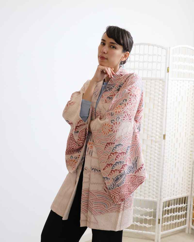 A woman wearing a pink kimono, facing forward.