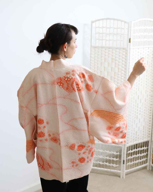 A woman wearing a pink kimono, facing backwards.