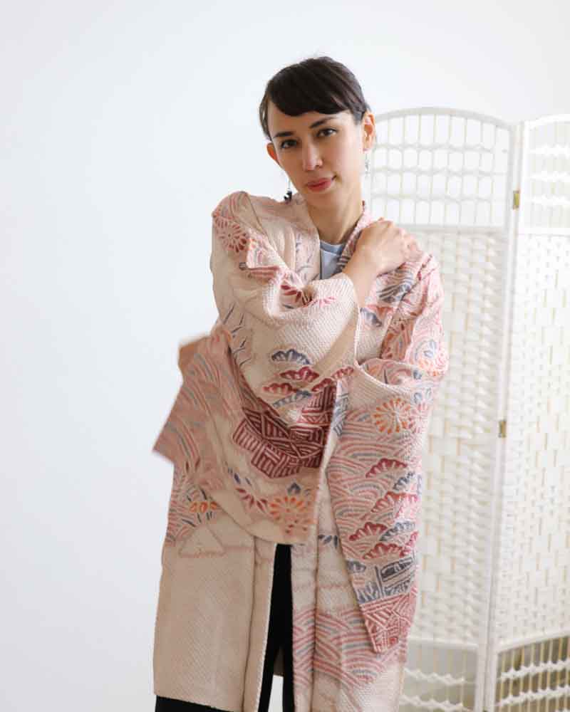 A woman wearing a pink kimono, facing forward.