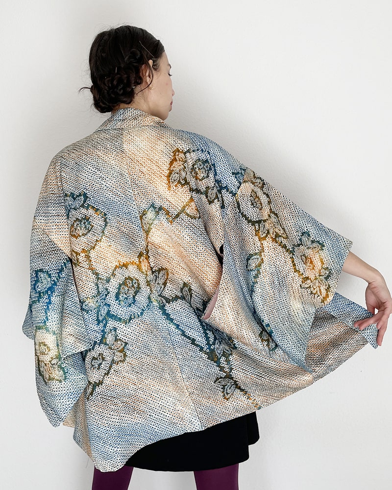 Back view of woman wearing Kimono zen brand Blue Blossom Shibori Haori Kimono Jacket with black dress and purple tights