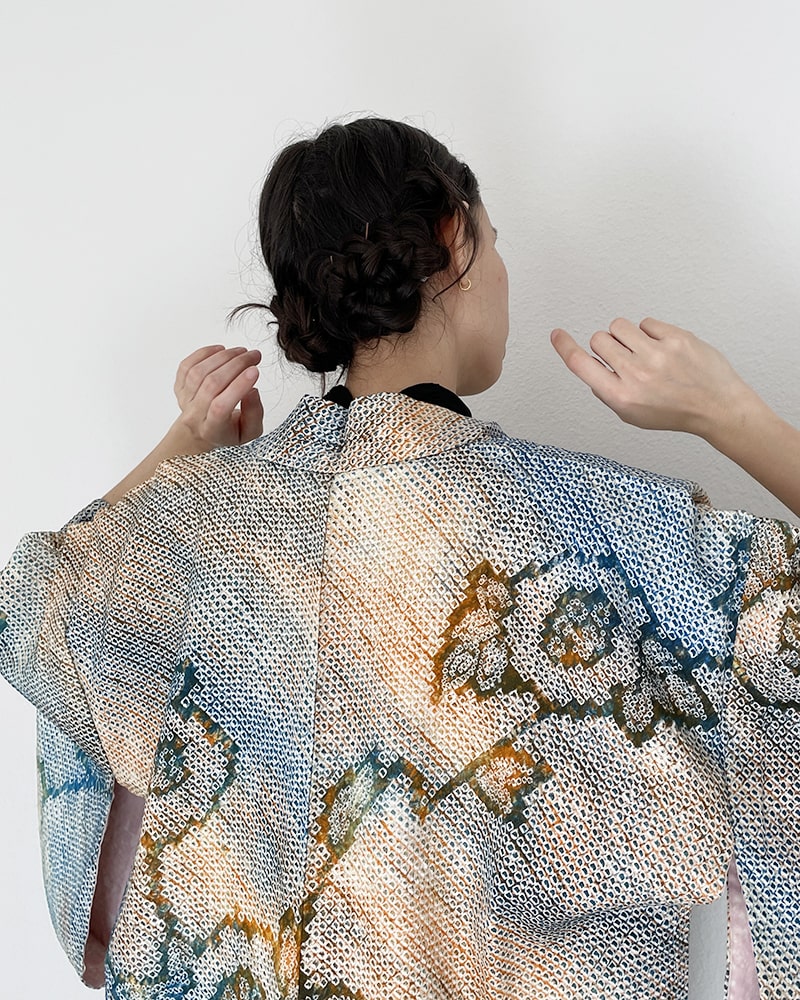 Back view of woman wearing Kimono zen brand Blue Blossom Shibori Haori Kimono Jacket with black dress and purple tights
