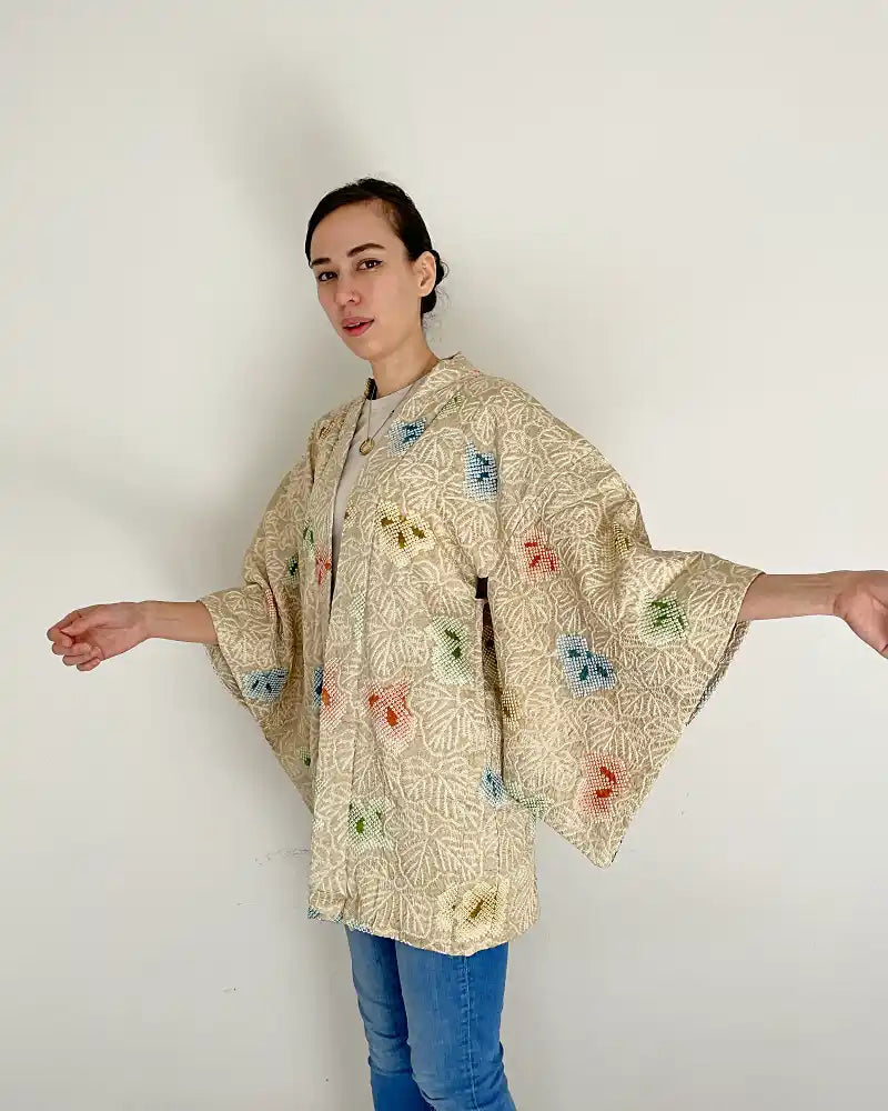 Woman showing the beatufil beige kimono jacket.