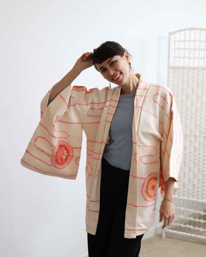 A woman wearing a Powder Pink kimono, facing forward.