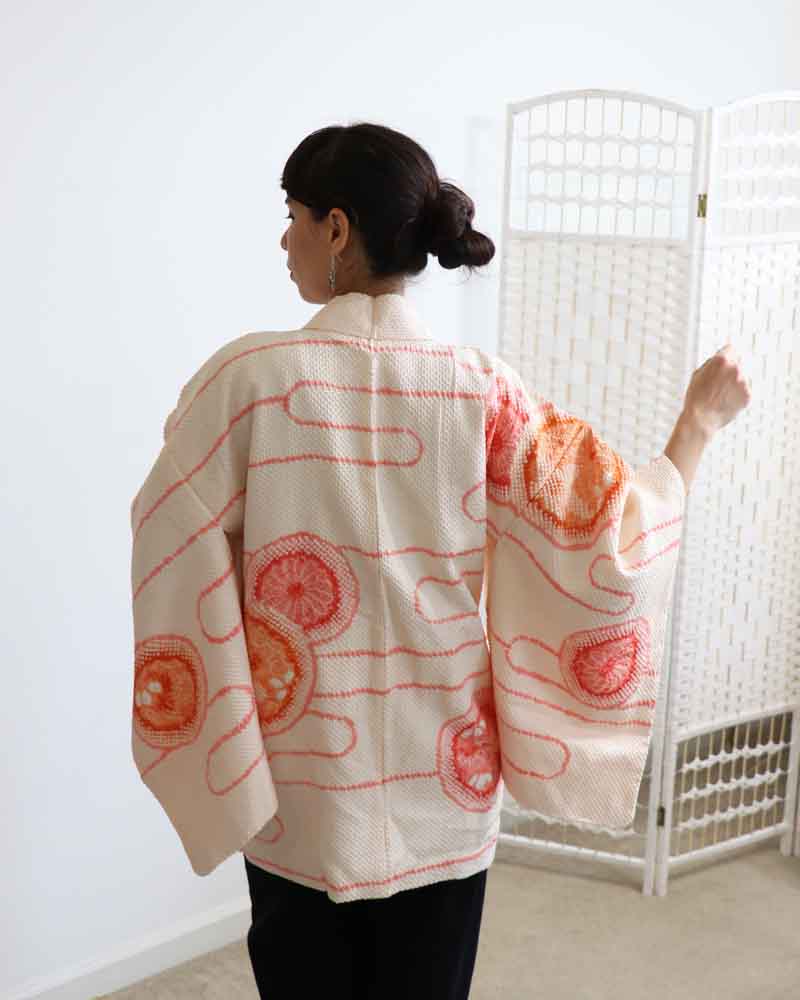 A woman wearing a Powder Pink kimono, facing backwards.