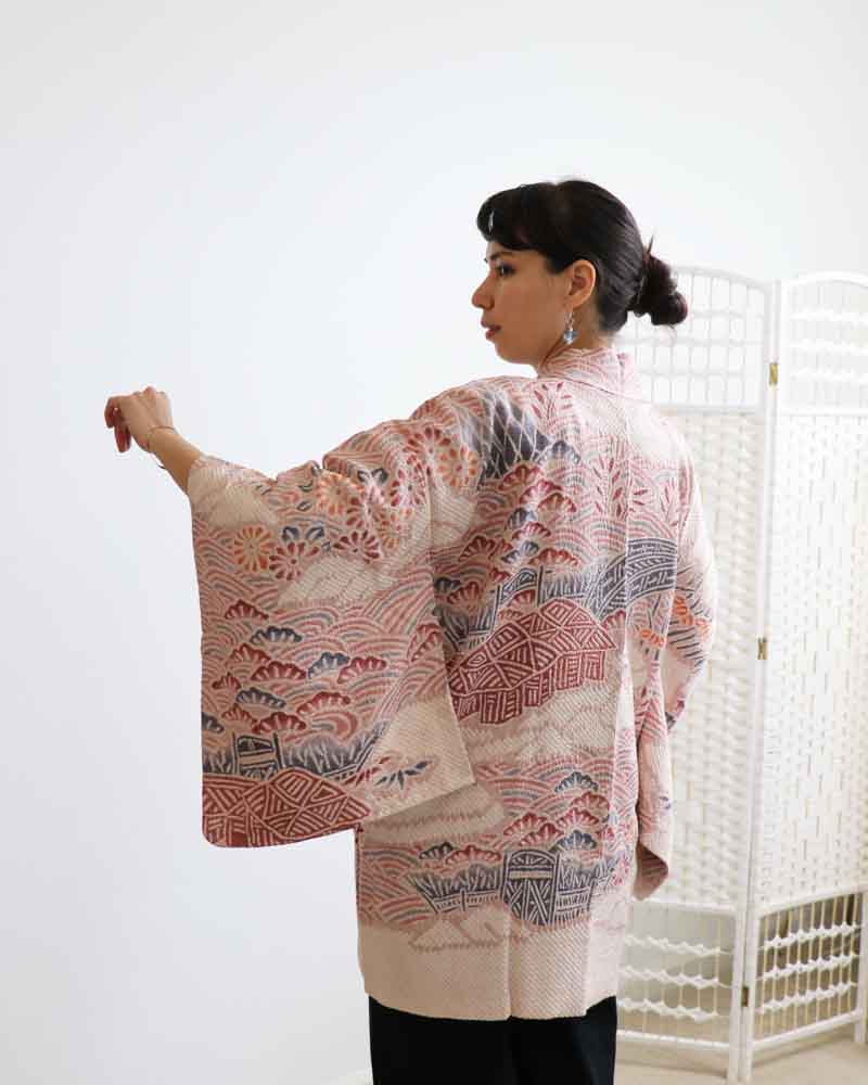 A woman wearing a  pink  kimono, facing backwards