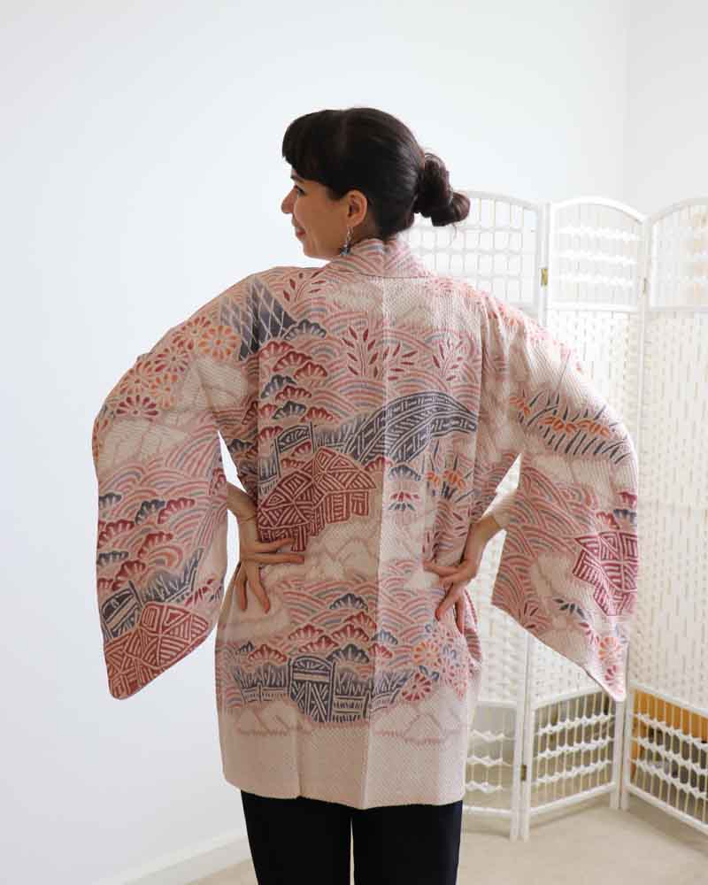 A woman wearing a  pink kimono, facing backwards