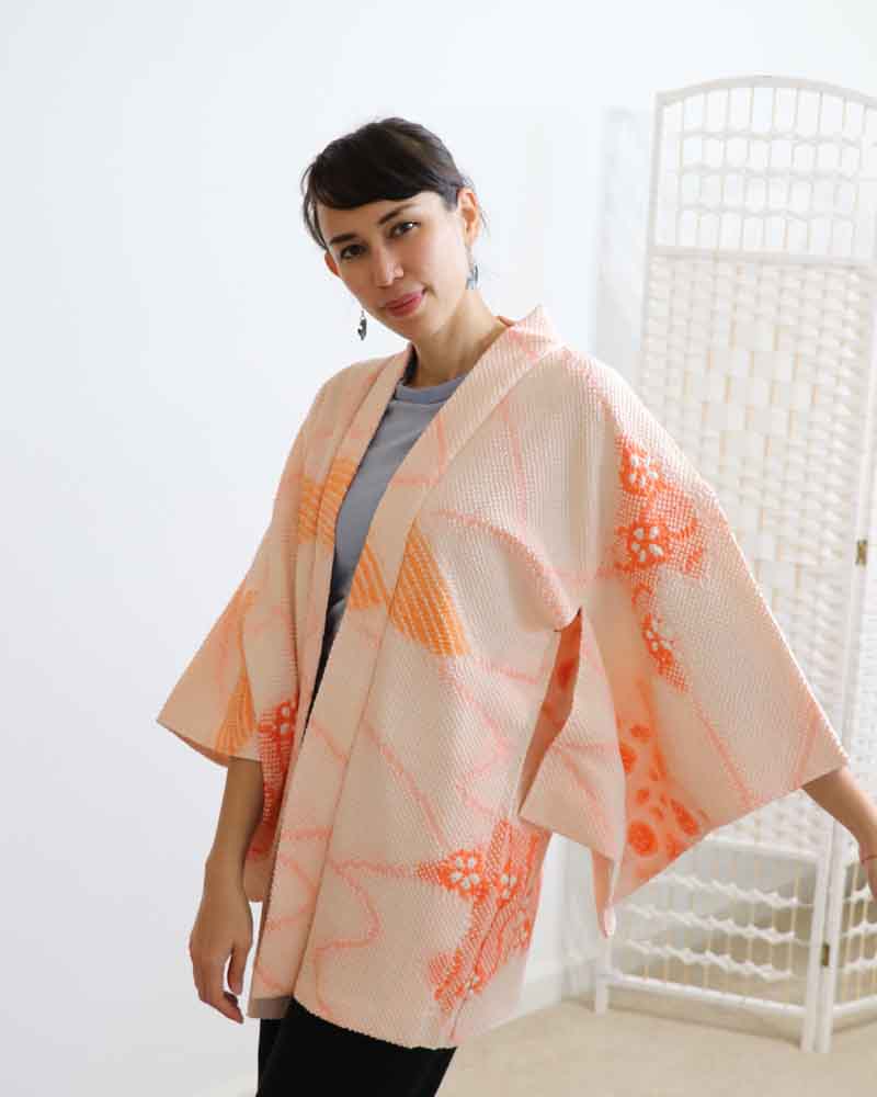 A woman wearing a pink kimono, facing forward.