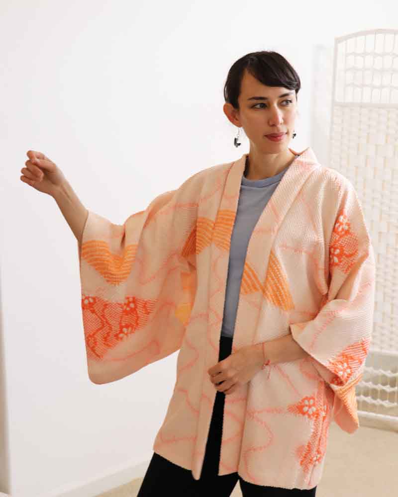 A woman wearing a pink kimono, facing forward.