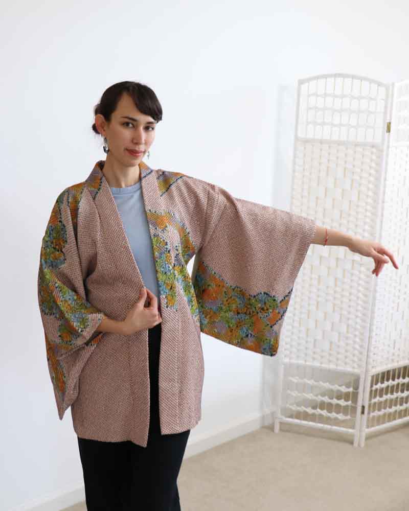 A woman wearing a multi colors kimono, facing forward.