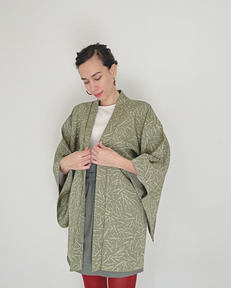 Bamboo leaves Haori Kimono Jacket of KIMONO ZEN brand, a woman wearing moss green color with white cut sleeves, gray skirt and red tights.