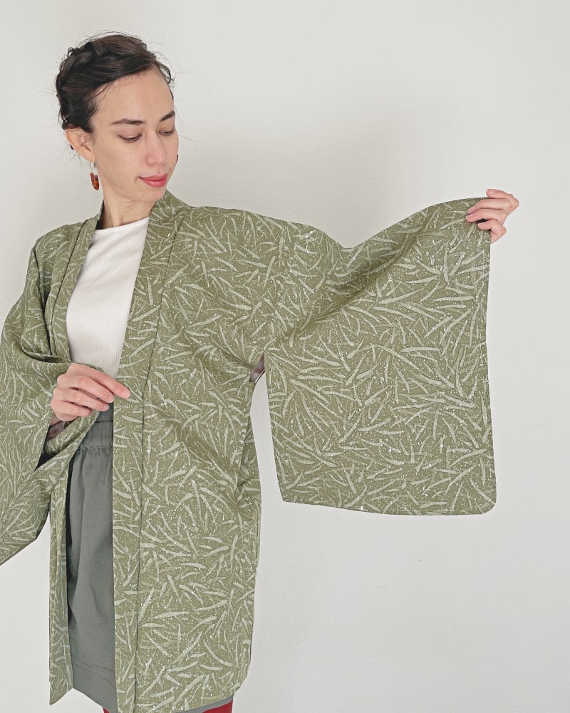 Bamboo leaves Haori Kimono Jacket of KIMONO ZEN brand, a woman in a white cut and gray skirt wearing a moss green color.