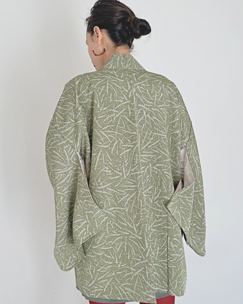 Back view of a woman wearing a KIMONO ZEN brand Bamboo leaves Haori Kimono Jacket in shades of moss green.