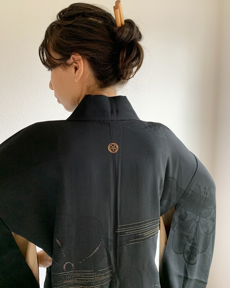 Back view of woman wearing Kimono zen brand Black with Aurora Glitter Thread Haori Kimono Jacket, black in color.