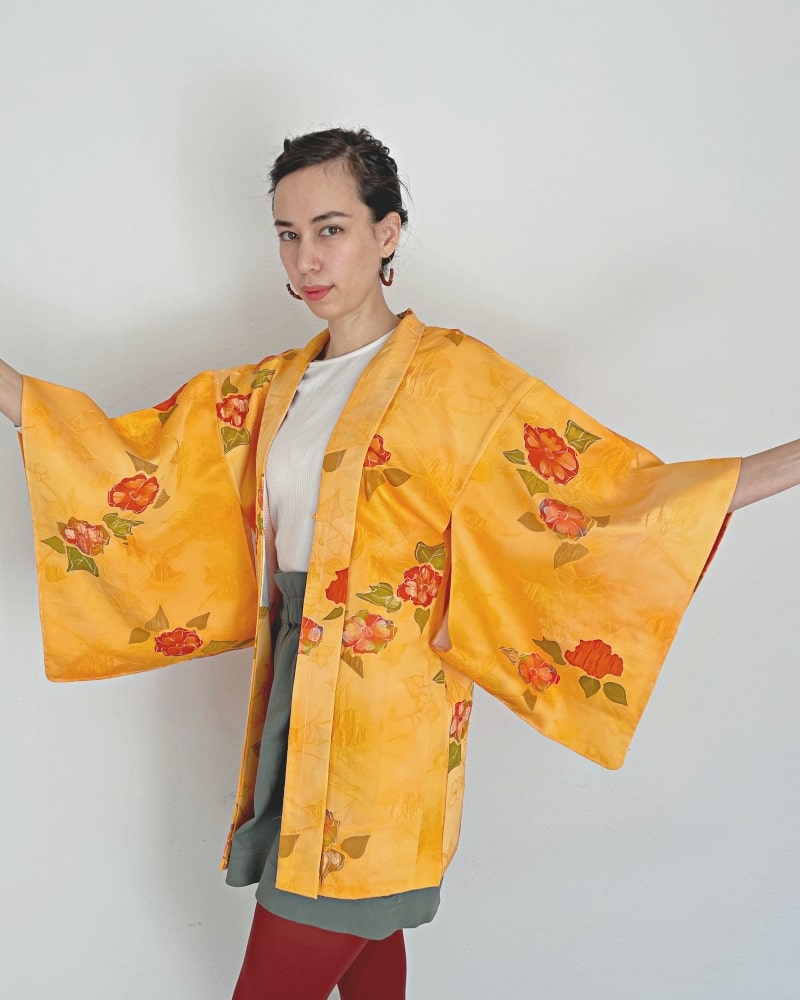 Woman wearing Kimono zen brand Bright Orange Floral Haori Kimono Jacket with white T-shirt, gray skirt and red/purple tights