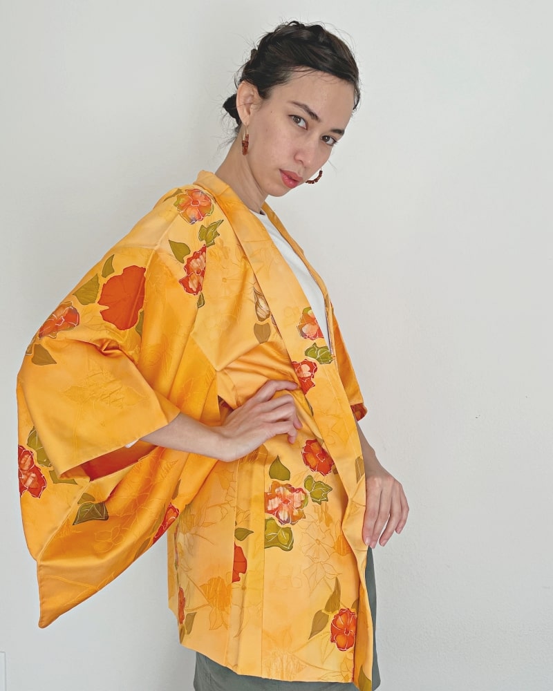 Woman wearing Kimono zen brand Bright Orange Floral Haori Kimono Jacket with white T-shirt, gray skirt and red/purple tights