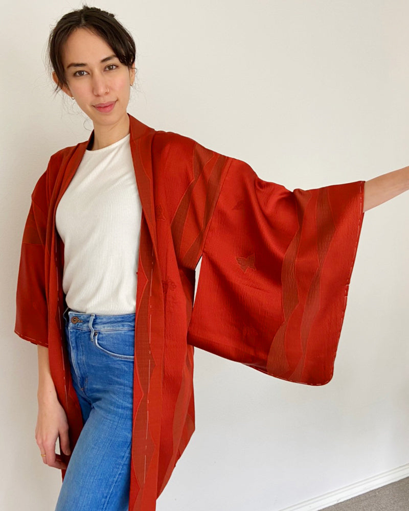Woman wearing red colored kimono haori jacket with white T-shirt and jeans