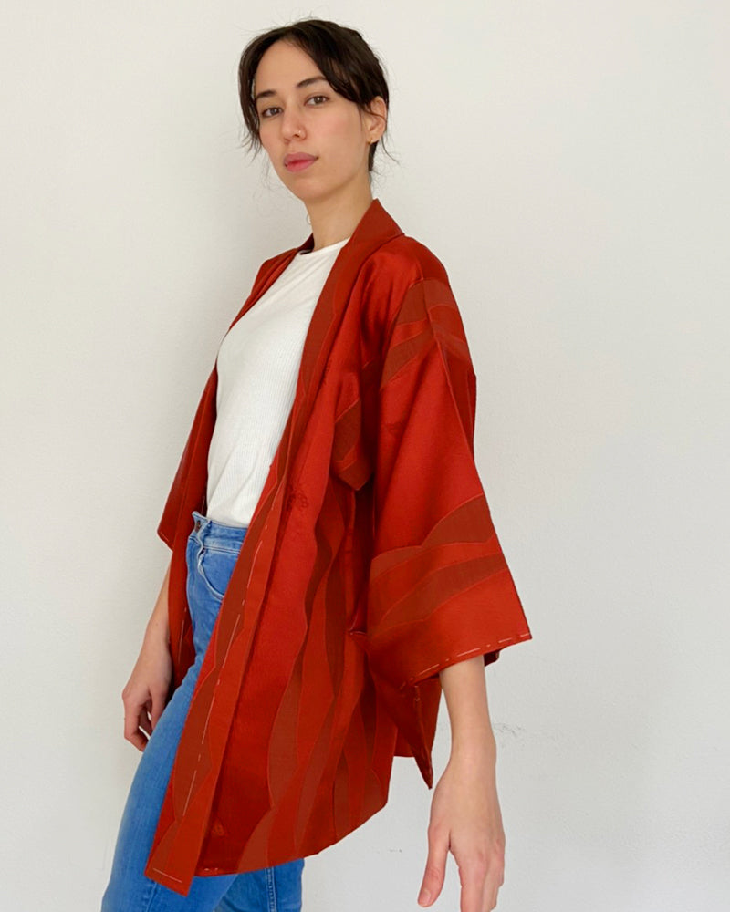 Woman wearing red colored kimono haori jacket with white T-shirt and jeans