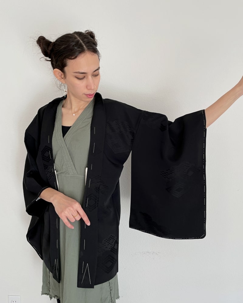 Black Rhombic Haori Kimono Jacket of Kimono zen brand, black fabric, upper body of a woman wearing a green dress with