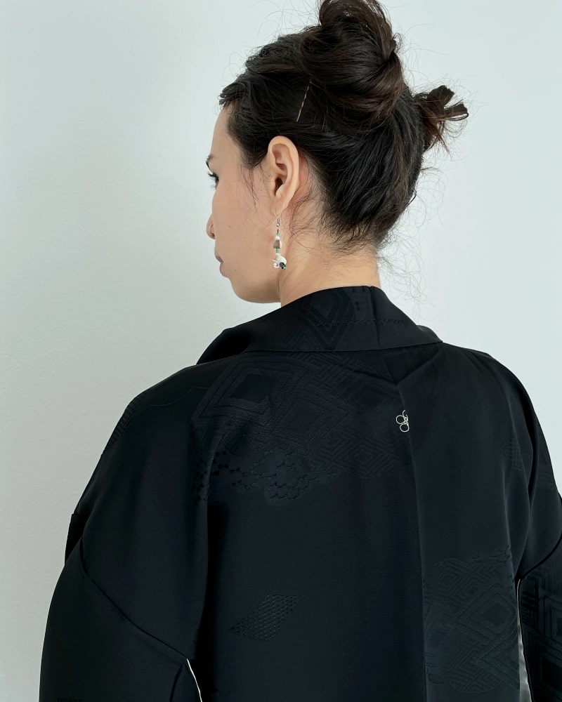 Black Rhombic Haori Kimono Jacket of Kimono zen brand, black fabric, back view of a woman wearing a green dress with it.