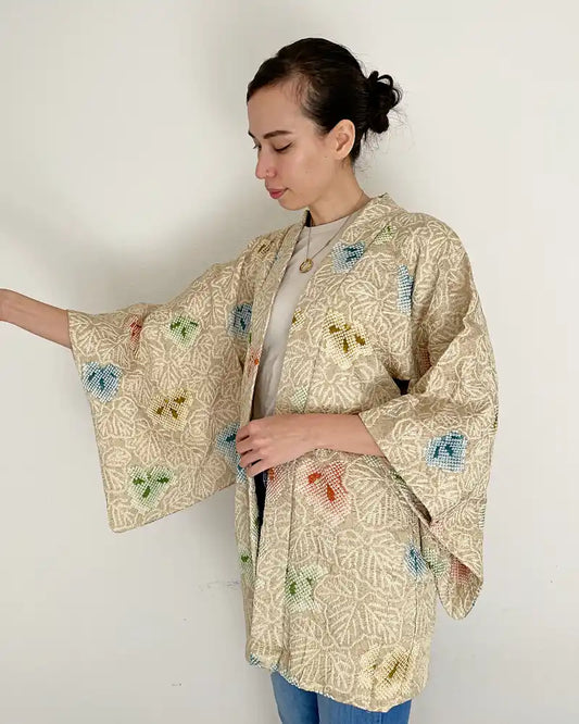 Woman waering beige kimono jacket.